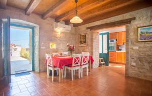 a kitchen and dining room with a red table and chairs at Villa Medvidići in Rajki