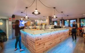 a woman standing at a bar in a restaurant at Yeah Barcelona Hostel in Barcelona