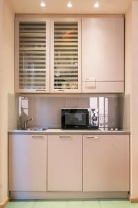 波隆那的住宿－Bologna elegance，厨房配有白色橱柜和微波炉