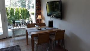 een eetkamer met een tafel en een tv aan de muur bij Cordes, Apartment 1 in Möhnesee