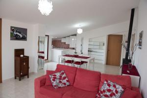 a living room with a red couch and a kitchen at Via del Mare in Lanciano