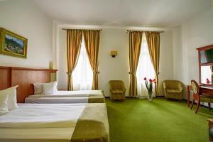a hotel room with two beds and a table and chairs at Hotel Palace in Băile Govora