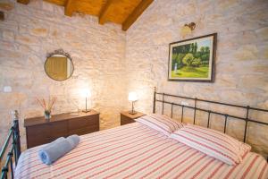 a bedroom with a bed in a stone wall at Villa Medvidići in Rajki +79 photos