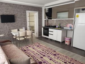 a kitchen and living room with a table and a white refrigerator at Dr Aslan Apart Hotel in Esenboga