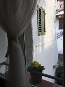 um vestido de noiva numa janela com um vaso de flores em Casa del Nespolo em Pilzone