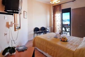 Zimmer mit einem Bett und einem Tisch mit einer Obstschale darauf in der Unterkunft Hotel Atlantis in Korfu-Stadt