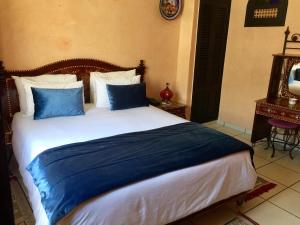 a bedroom with a large bed with blue pillows at Essaouira Wind Palace in Essaouira