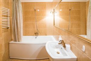 bagno con lavandino, vasca e servizi igienici di 2 Virmens'ka Apartment a Lviv