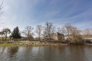 a house on the bank of a river at Hotel La Passerelle in Grandhan