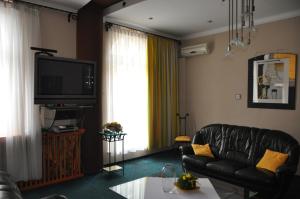 a living room with a black leather couch and a television at Rynkowy in Rybnik