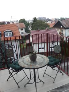stół i 2 krzesła na balkonie ze stołem w obiekcie Apartmam "Mavi" w mieście Varaždin