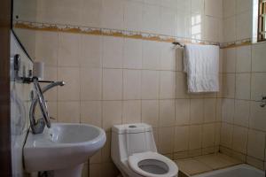 a bathroom with a toilet and a sink at Royal Crane Resort in Arua
