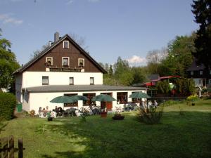 ein Gebäude mit einer Gruppe von Menschen, die draußen sitzen in der Unterkunft Pension Klette in Kurort Oybin