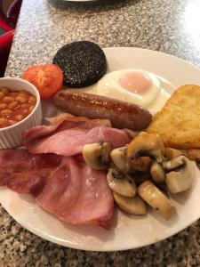 a plate of breakfast food with sausage mushrooms and beans at Storrbeck Guest House in Whitby