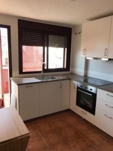 eine Küche mit weißen Schränken, einem Waschbecken und einem Fenster in der Unterkunft Piscina y playa a 2 kilómetros Alojamiento grande para familias in San Juan de Alicante