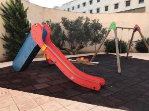 einen Spielplatz mit Rutsche und Schaukel in der Unterkunft Piscina y playa a 2 kilómetros Alojamiento grande para familias in San Juan de Alicante