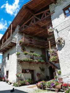 ein Gebäude mit Blumenkästen und Balkonen darauf in der Unterkunft Agriturismo Barba Gust in Cesana Torinese