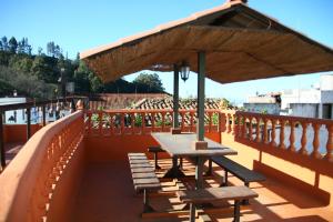 a picnic table with an umbrella on a deck at Cabañas Valle Verde in Moya