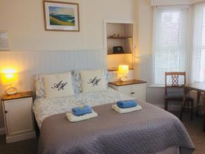 a bedroom with a bed with two towels on it at Arden House in Arundel