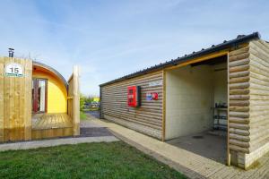 un edificio con un teléfono público junto a un garaje en Deluxe Glamping Pod with Hot Tub, en Frodsham