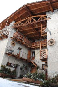 a building with a wooden roof and balconies on it at Agriturismo Barba Gust in Cesana Torinese