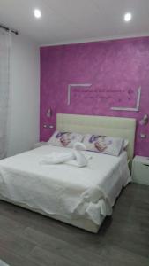a bedroom with a large bed with a purple wall at Dolce Vita Lovely Suites in Cavriago