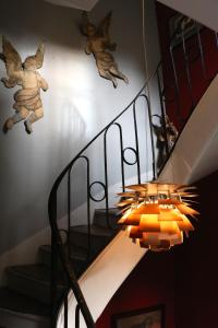 a staircase with a chandelier next to a stair case at Le 66 in Paris
