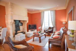 a living room filled with furniture and a fireplace at Domaine de La Ramée in Trévières