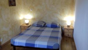 un letto blu e bianco in una stanza con due luci di Chambres d'hôtes d'Antardieu a Saint-Junien