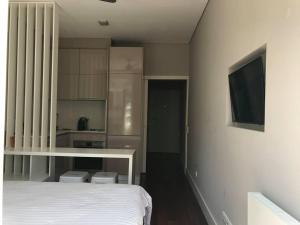 a bedroom with a white bed and a television at Apartamento Cardosas, São Bento in Porto