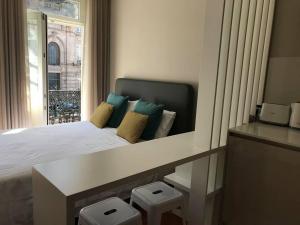 ein Schlafzimmer mit einem Bett mit Kissen und einem Fenster in der Unterkunft Apartamento Cardosas, São Bento in Porto
