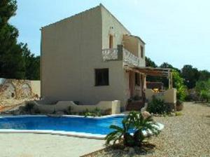 una casa con piscina frente a una casa en Casa Peregil, en Perelló