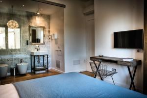 a bedroom with a bed and a bathroom with a sink at Teku Sardinia Boutique Hotel in Bari Sardo