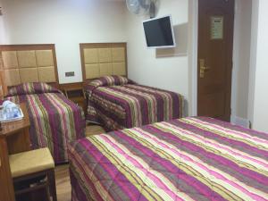 a hotel room with two beds and a tv at White House Hotel in London