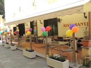 a row of tables and chairs with balloons in front of a restaurant at Hotel Doria in Varazze