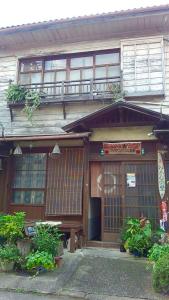 Edificio antiguo con puerta y balcón en Buddha Guest House, en Tanabe
