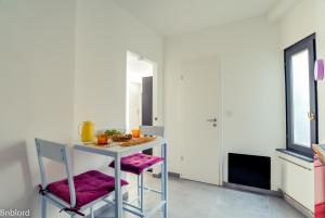 une cuisine avec une table et deux tabourets dans l'établissement Appartement Place Kléber, à Strasbourg