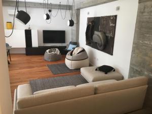 a living room with a couch and a tv at Teku Sardinia Boutique Hotel in Bari Sardo