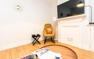 ケンブリッジにあるThe Modern Classic - Contemporary & Elegant 3BDR Homeのリビングルーム(テーブル、黄色い椅子付)