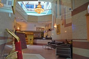 una hall dell'ospedale con divani e lampadario a braccio di Queens Hotel a Dubai