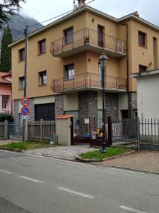 duży żółty budynek z balkonem na ulicy w obiekcie Gardens House w mieście Varenna