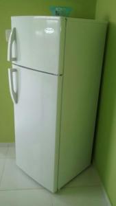 um frigorífico branco num quarto com uma parede verde em Casa Vasquez em San Felipe de Puerto Plata