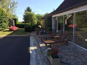 a patio with two benches next to a house at La Ferme Briarde in Couperdrix