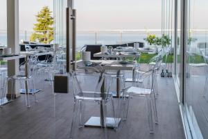 Ein Zimmer mit Tischen und Stühlen und Meerblick in der Unterkunft Hotel Villa Katy in Bardolino