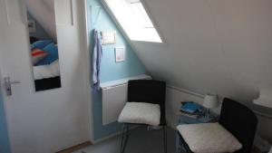 a small attic room with two chairs and a bed at Bed en Breakfast kamers en meer Het Spookhuis in Den Hoorn