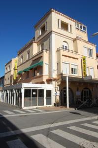 un grand bâtiment dans une rue avec un passage dans l'établissement Hotel De La Plage, à Valras-Plage