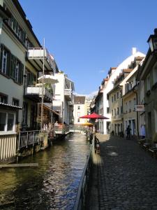 een kanaal in een stad met gebouwen naast een straat bij Altstadtloft am Martinstor in Freiburg im Breisgau