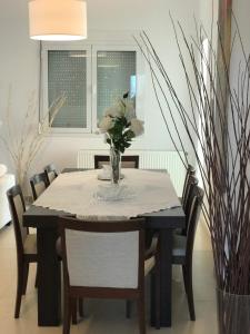 una mesa de comedor con un jarrón de flores. en Villa Korais Luxury 3br apt with sea view, en Tesalónica