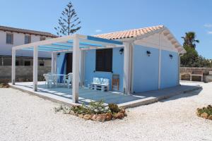 una casa azul con techo en una playa en Casa azzurra, en Reitani