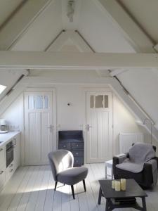 a living room with two chairs and a table at Vlasoven loft in Noordwijkerhout
